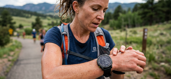 Endurance runner looking at smartwatch to check resting heart rate during aerobic recovery
